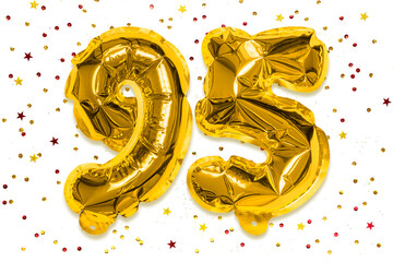 The number of the balloon made of golden foil, the number ninety five on a white background with multicolored sequins. Birthday greeting card with inscription 95. Anniversary concept.