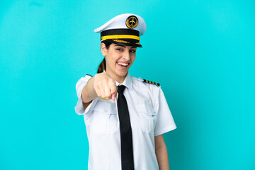 Airplane pilot caucasian woman isolated on blue background pointing front with happy expression