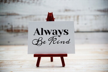 Always Be Kind text on paper card with wooden background