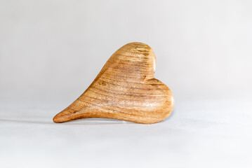 The wooden heart on white material.Heart shaped wooden plate on white background.Copy space.Valentines day concept.