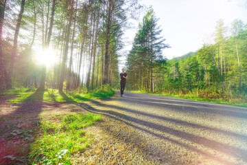 Running man jogging in city park at beautiful summer day. Sport fitness model caucasian ethnicity training outdoor.