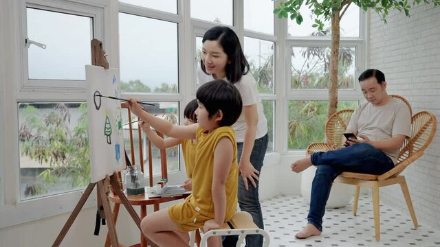 Asian family with father Mother and son are working together to paint and paint in the living room.
