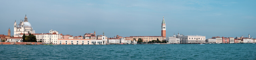 Fototapeta na wymiar Venice, panoramic image of central Venice from lagoon. City skyline with Punta della Dogana, church Santa Maria della Salute, Doge's palace and St Mark's Campanile tower. Banner composition.