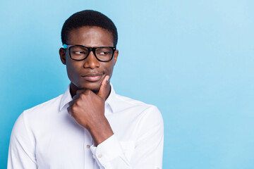 Photo of pretty serious dark skin man wear white shirt arm chin looking empty space isolated blue...