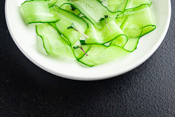 cucumber salad slices vegetable ready to eat meal snack on the table copy space food background rustic. top view keto or paleo diet veggie vegan or vegetarian food