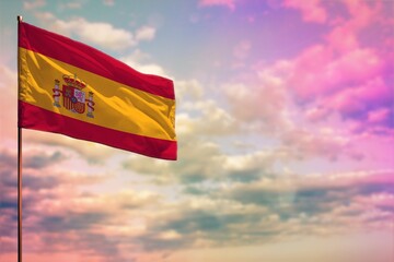 Fluttering Spain flag mockup with the space for your content on colorful cloudy sky background.