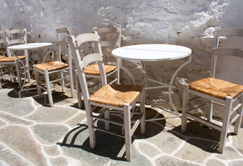 Charming Greek island of Sikinos Old fashioned taverna tables and chairs. Landscape aspect view.