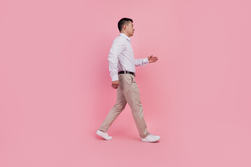 Fototapeta na wymiar Full size profile side photo of young asian man formalwear walk meeting isolated over pink color background