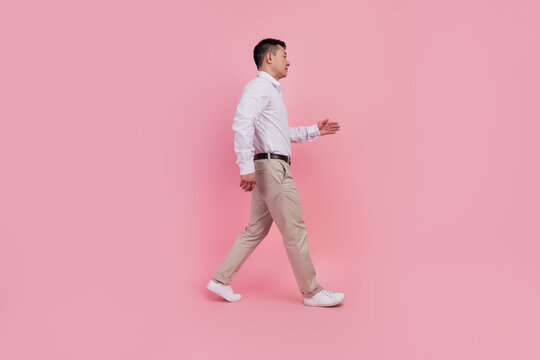 Full size profile side photo of young asian man formalwear walk meeting isolated over pink color background