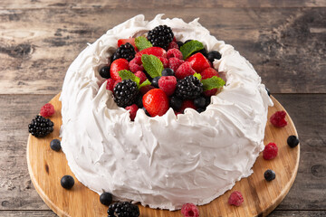 Delicious Pavlova cake with meringue topped and fresh berries on wooden table