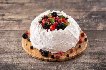 Delicious Pavlova cake with meringue topped and fresh berries on wooden table