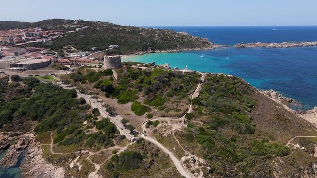 Aerial view of Rena Bianca, Sardinia, passing above spanish tower, taken on summer day Italy Santa Teresa Gallura.