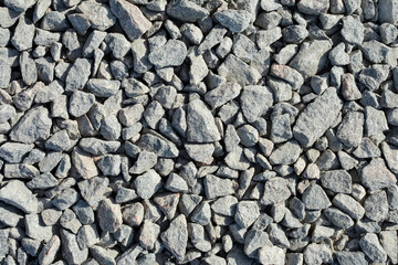 gray stone background. a lot of fine gravel lies on the road