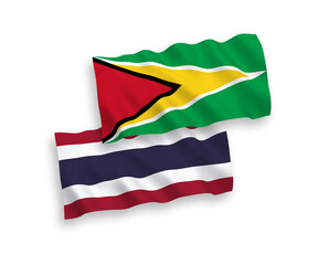 National vector fabric wave flags of Co-operative Republic of Guyana and Thailand isolated on white background. 1 to 2 proportion.