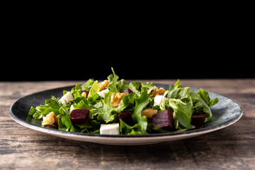 Beetroot salad with feta cheese,lettuce and walnuts on rustic wooden table	