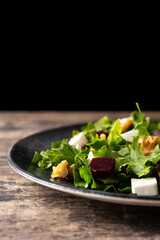 Beetroot salad with feta cheese,lettuce and walnuts on rustic wooden table	