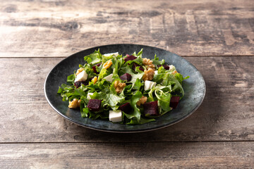 Beetroot salad with feta cheese,lettuce and walnuts on rustic wooden table	