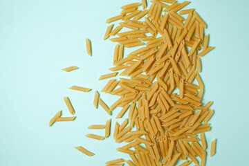 Penne pasta background. Pasta Penne texture background with space for text. Tube like macaroni. Heap of pasta.