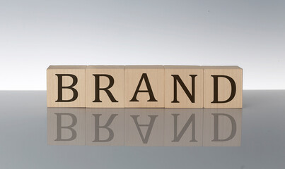 BRAND concept, wooden word block on the grey background