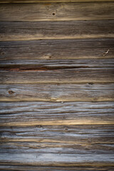 Wooden logs of an old house. Close-up. Weathered natural gray wood texture. Background. vertical photo.