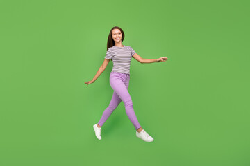 Fototapeta na wymiar Full length body size view of attractive cheerful girl jumping going rest isolated over bright green color background