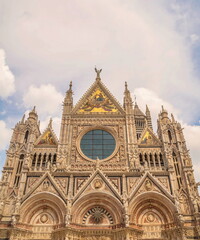Naklejka premium Fragment of the Cathedral with sculptures on the facade in Siena