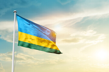 Rwanda national flag cloth fabric waving on the sky - Image
