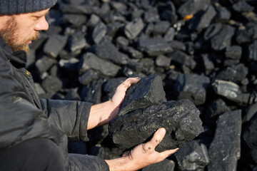 poor middle-aged man holding the hands of stone coal for sale to provide food for his family