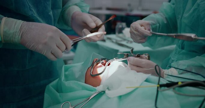 The doctor performs a pediatric surgical operation to remove the tonsils. Tonsillectomy.