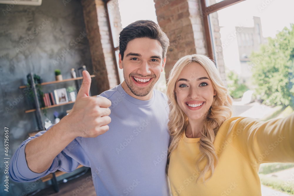 Poster self-portrait of handsome beautiful cheerful couple showing thumbup positive at home loft industrial