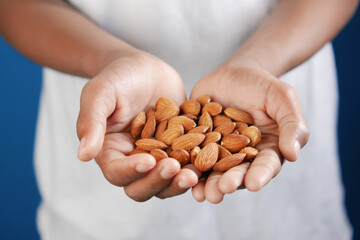 close up of almond nuts on man's hand 