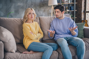 Photo of young couple unhappy negative moody conflict quarrel argument offended speak sit sofa indoors - obrazy, fototapety, plakaty