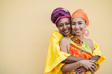Happy mother and daughter with traditional african dresses smiling on camera - Focus on senior...