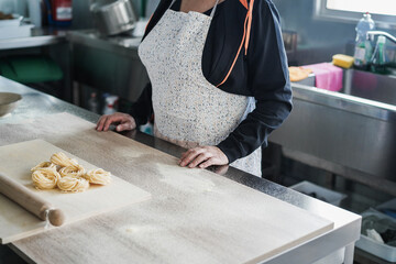 Woman prepare traditional pasta inside italian factory