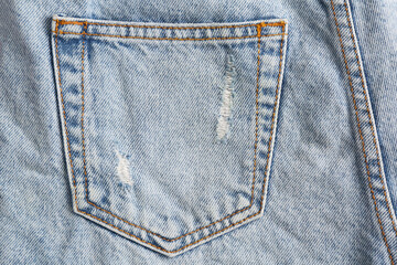 Light blue jeans with back pocket as background, closeup