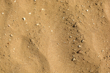 texture of sandy beach with small pebbles. sand background. view from above