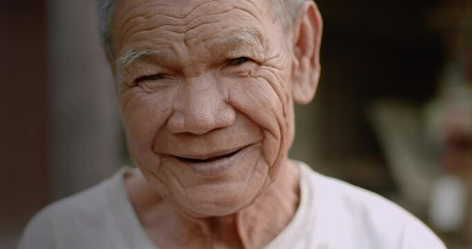 An Asian senior male farmer at countryside is smiling happily in a countryside.