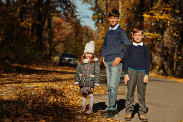 Three kids posing at autumn fall park.