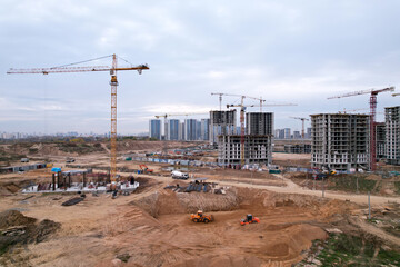 Tower crane at buildings construction. Soil Compactor at construction site. Vibration...