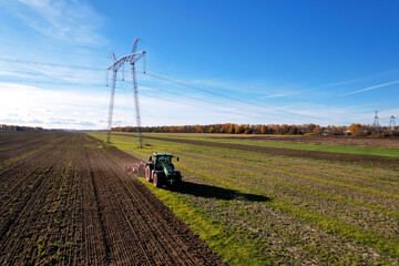 Tractor with Plough on Plowed. Ploughing and Soil Tillage. Agricultural Tractor on Cultivation Field for Sowing Seeds. Tractor During Field Cultivating. Planting and Seeding Equipment.