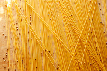 Spaghetti scattered on the table with black pepper peas. Italian food concept. Spaghetti background for post, screensaver, wallpaper, postcard, poster, banner, cover, header for website. Food photo