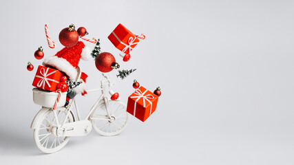 Christmas composition with retro bicycle with red gifts and presents flying out of basket on bright white background. Creative Xmas delivery concept. New year shopping banner with copy space.