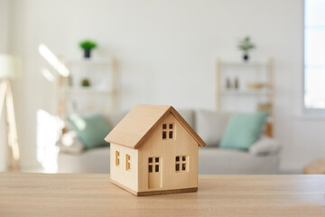 Close up of wooden house model on table in modern real estate agent office. Home building cottage maquette in realtor broker company. Bank property loan mortgage. Rent, realty concept.