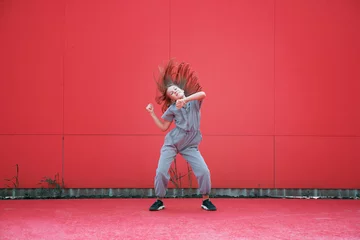 Stickers pour porte École de danse Energetic teen girl dancing waving hair outdoors by red wall. Dancer performance. Contemporary dance school advertising