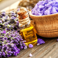 lavender's spa products with dried lavender flowers on a wooden table. Flat lay bath salt and massage oil on wooden background. Skin care, beauty treatment concept. Lavendula oleum