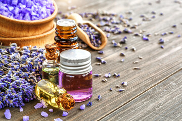 Obraz na płótnie Canvas lavender's spa products with dried lavender flowers on a wooden table. Flat lay bath salt and massage oil on wooden background. Skin care, beauty treatment concept. Lavendula oleum