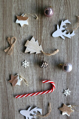 Various Christmas ornaments and candy cane on wooden background. Flat lay.