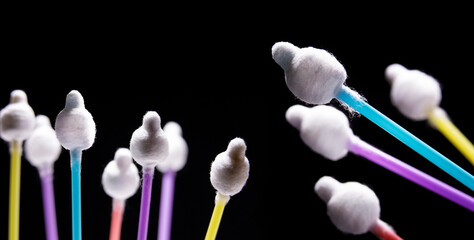 Colorful cotton sticks, cotton buds isolated on black background.