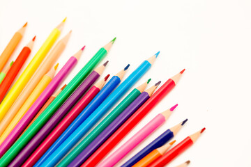 School stationery items. Creation Multicolored pencils on a blank white sheet. On a white background. Children's drawing, artist.