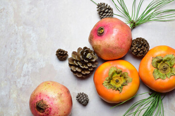 Top view, autumn fruit, persimmon and pomegranate, on marble background.